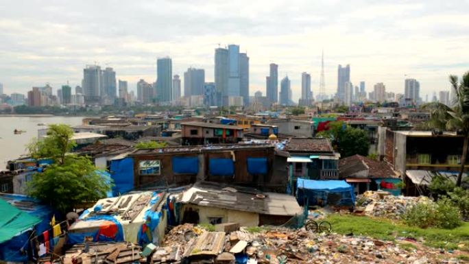 在正在建造的摩天大楼的背景下，印度孟买海岸上的贫民窟的景色