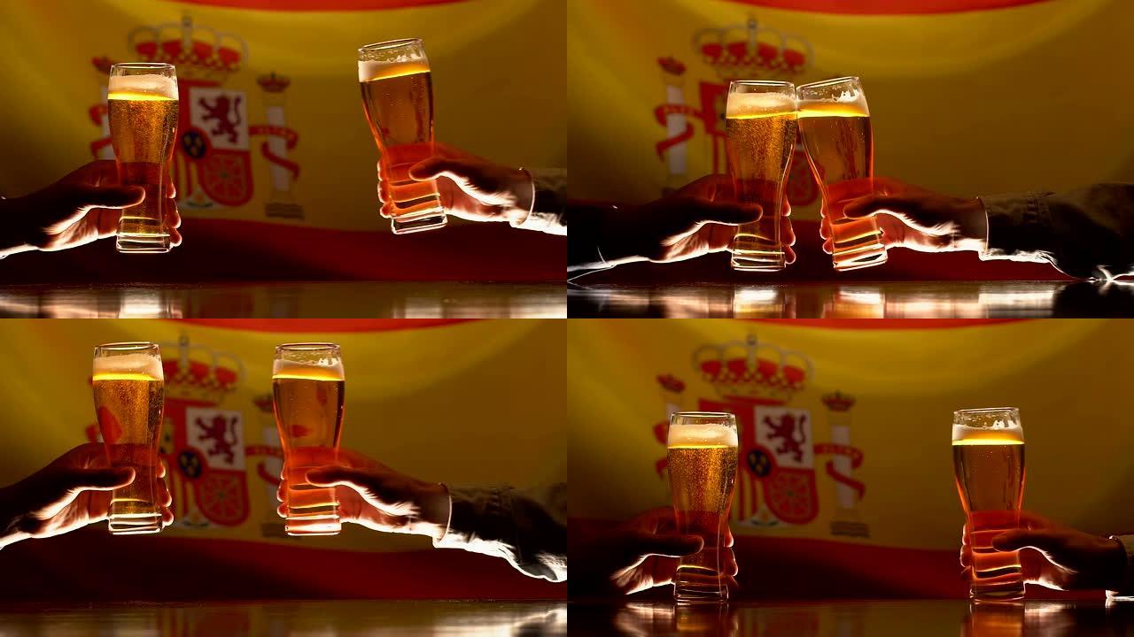 男人碰碰啤酒玻璃杯，背景上的西班牙国旗，在酒吧里休息的体育迷