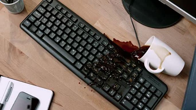 SLO MO LD用笔记本打翻一杯咖啡，并将其洒在计算机键盘上