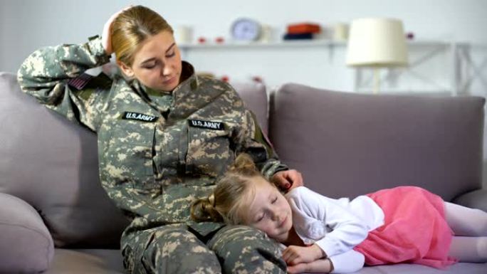慈祥的美国军人母亲抚摸着睡在沙发上的孩子，回家