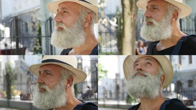 大胡子的老人走在城市的街道上
