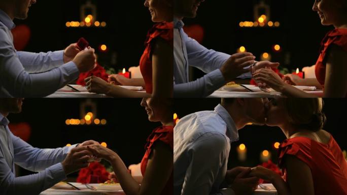 男朋友把珍贵的戒指戴在女性手指上，情侣温柔地接吻，礼物