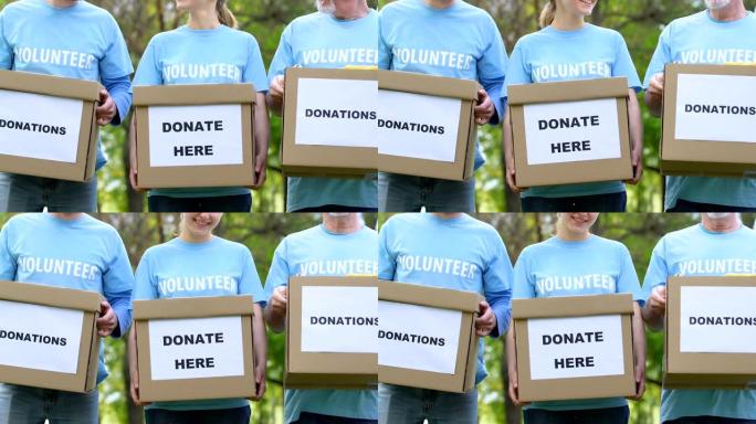 善良的志愿者拿着捐款箱微笑，社会慈善项目，帮助
