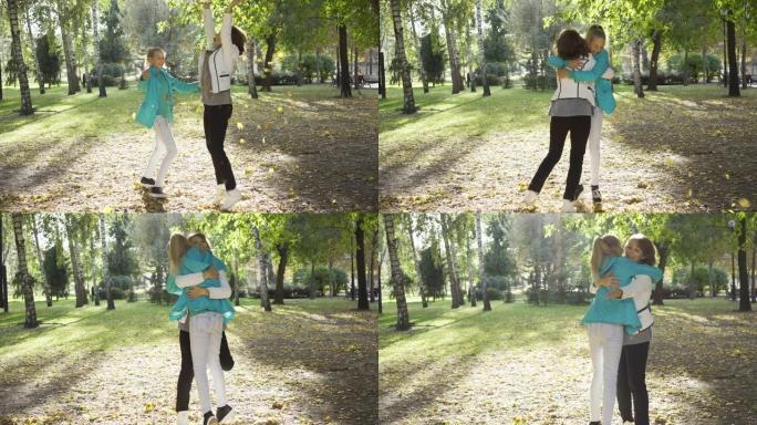 母女俩扔树叶拥抱。两个快乐的高加索女人在秋季公园玩得开心