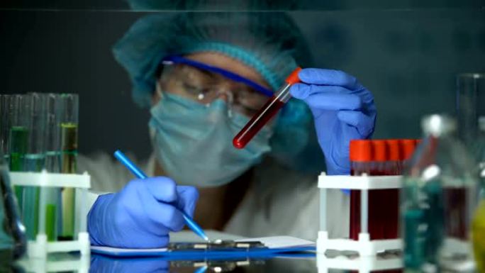 科学家用血液分析检查试管并做笔记，疫情爆发