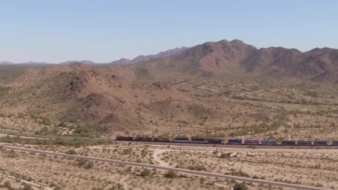 在晴朗，阳光明媚的日子里，一列火车穿越亚利桑那州马里科帕附近的索诺兰沙漠国家纪念碑的空中无人机拍摄