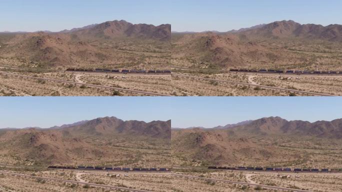 在晴朗，阳光明媚的日子里，一列火车穿越亚利桑那州马里科帕附近的索诺兰沙漠国家纪念碑的空中无人机拍摄