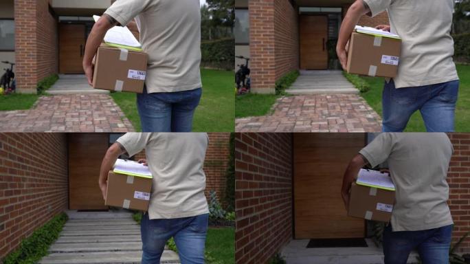 无法识别的邮政工作人员在房子里运送包裹，看着带有文件的剪贴板