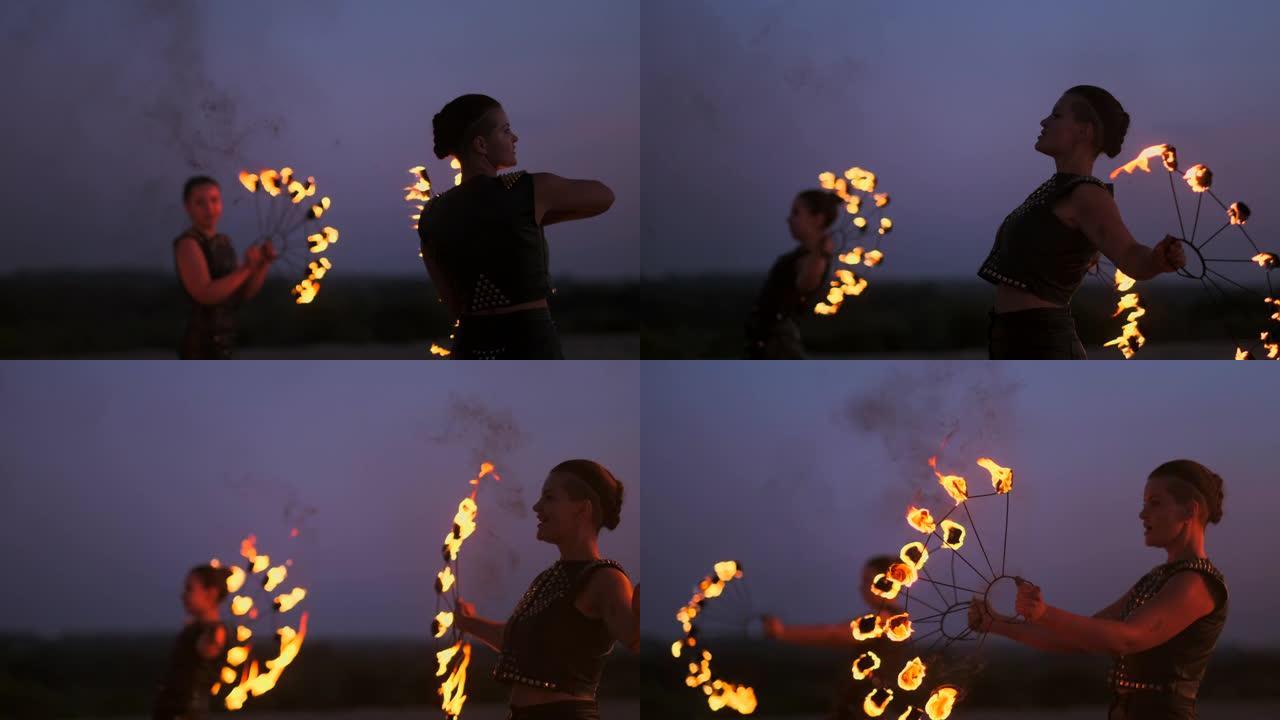 一群专业的马戏团表演者用火表演慢动作表演舞蹈表演，使用喷火器和旋转火炬燃烧的物体。