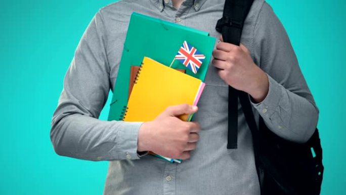 学生手持带有英国国旗的笔记本，国际教育计划