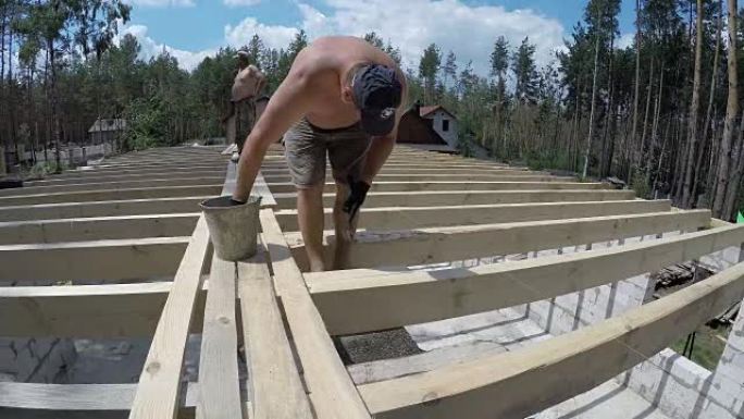 屋顶的建造。建造者将横梁钉在底座上。