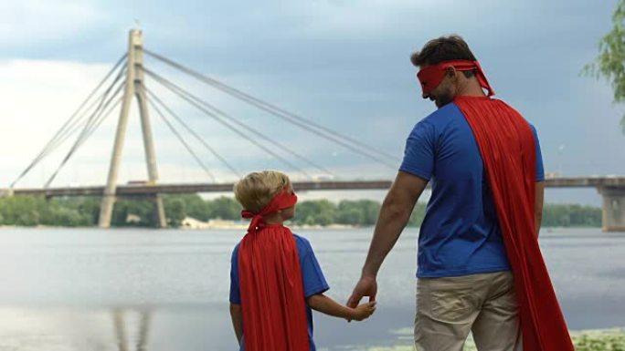 爸爸和儿子作为超人团队看着城市，为成功的未来而努力