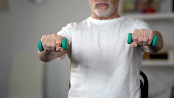 老人举起哑铃，在受伤或侮辱后训练肌肉和关节