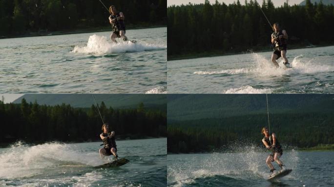 在一个阳光明媚的下午，一名二十多岁的白人男性站起来跳起来，在蒙大拿州维克多附近的格伦湖的滑水板上表演