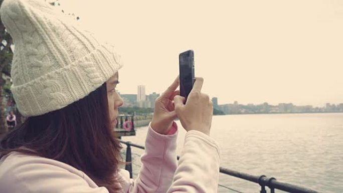 女人用数字平板电脑拍照，台湾淡水