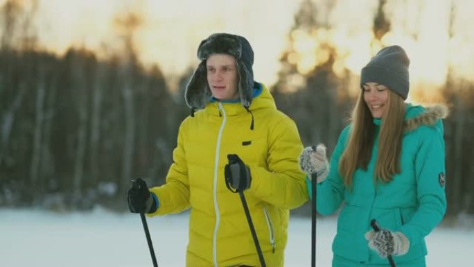 在冬季森林的滑雪行走中，有爱心的年轻人帮助受伤的女友的全长肖像