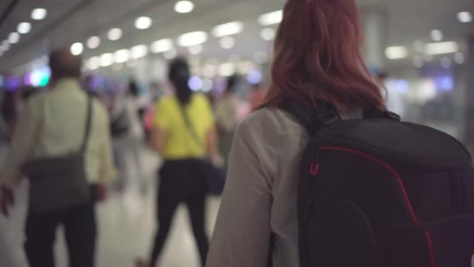 4k镜头航空公司的乘客在黄昏时分在机场大厅里走着行李。