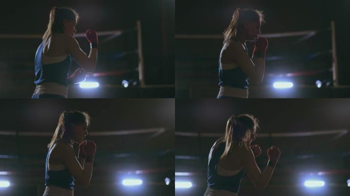 一个美丽的女人在为未来的胜利努力练习的同时进行影子战斗。黑暗的健身房背景。steadicam射击
