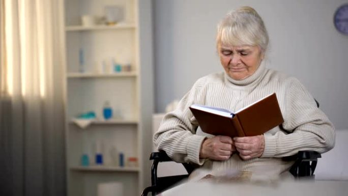 老妇人坐在轮椅上看书，寻找眼镜，视力不好