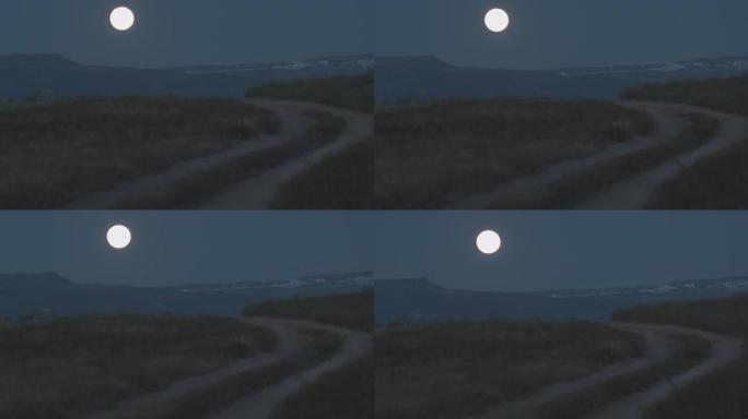 几乎满月升起在俯瞰科罗拉多州大章克申的大梅萨上，前景是一条土路