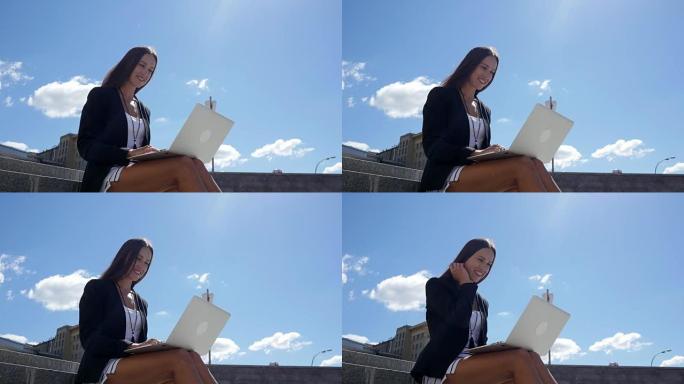 带笔记本电脑的女商人在外面看着商业区的屏幕