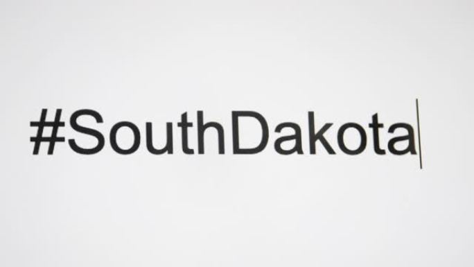 一个人在他们的计算机屏幕上键入 “# SouthDakota”，然后使用状态缩写