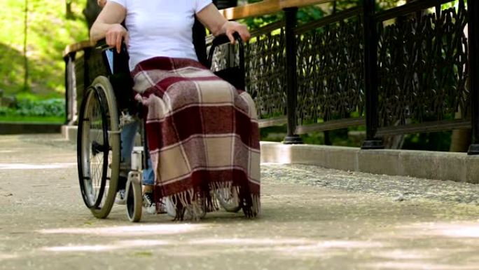 志愿者与残疾人在公园轮椅上行走，康复