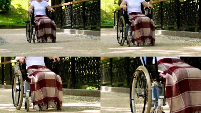 志愿者与残疾人在公园轮椅上行走，康复
