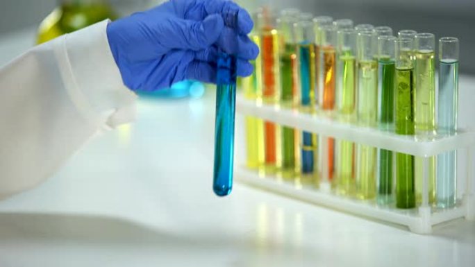 实验室助理用蓝色液体检查管子中的沉淀物，洗涤物质