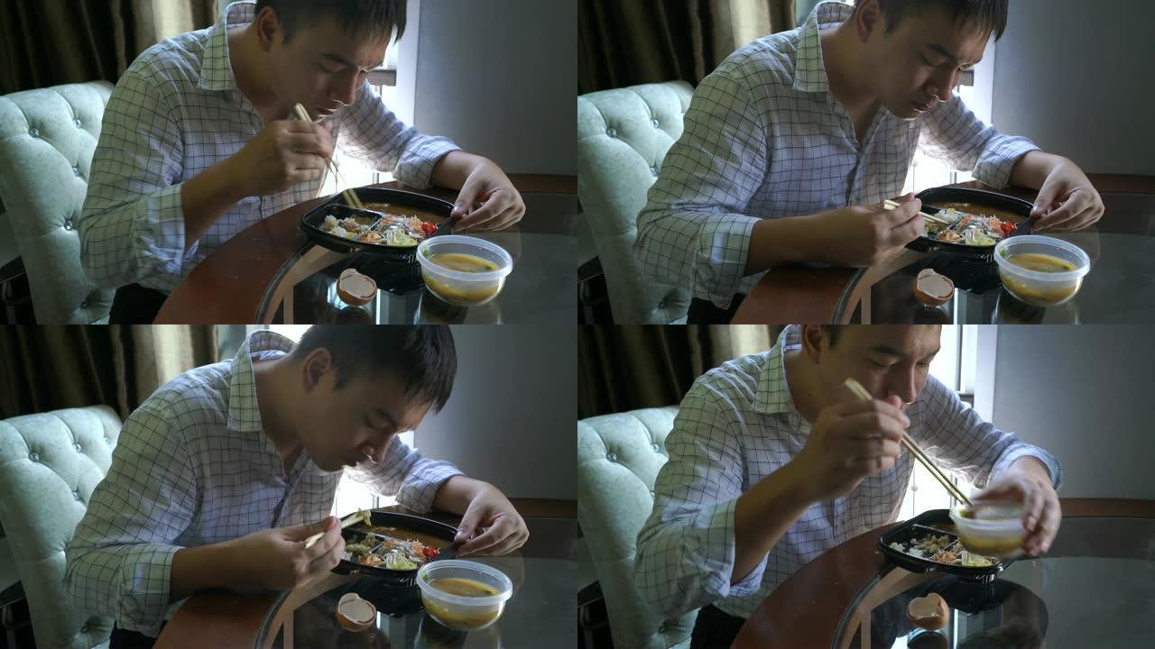 穿着工作服的男人在办公室的午休时间吃日本食物。