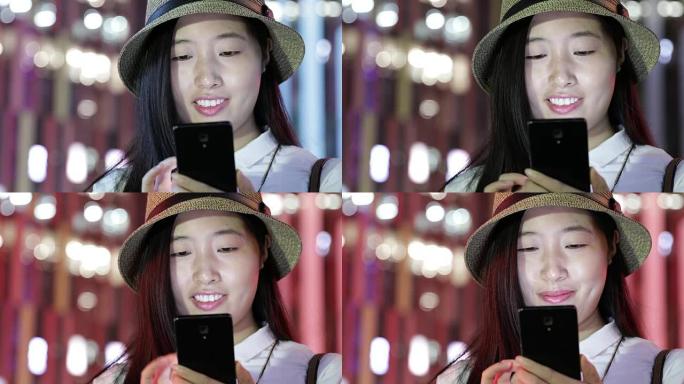 美丽的女人在城市的智能手机上发短信