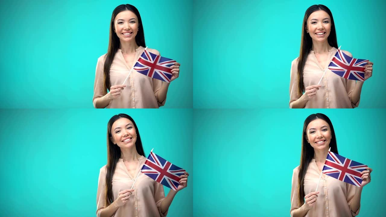 微笑的女人举着英国国旗，准备学习外语
