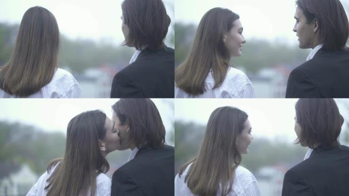 美丽的女孩亲吻她的男朋友在户外的脸颊上，男人和女朋友在一起度过时光