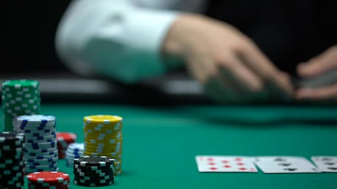 赌场庄家将牌放在绿桌上，扑克游戏，赌博，特写