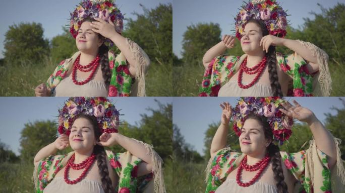 可爱的丰满女人的肖像，头上戴着花环，在绿色的夏日田野上，在阳光下微笑。