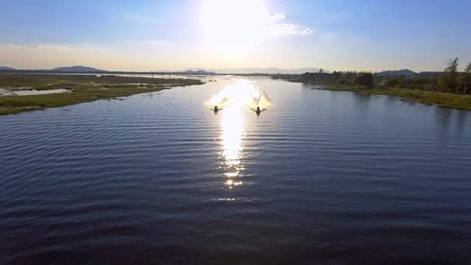 日落时湖中两艘喷气船的鸟瞰图