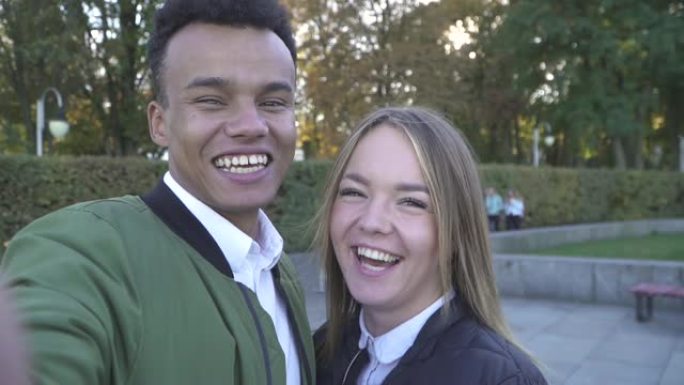 微笑的青少年跨种族夫妇拍摄自己的镜头。