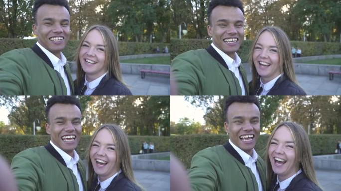 微笑的青少年跨种族夫妇拍摄自己的镜头。