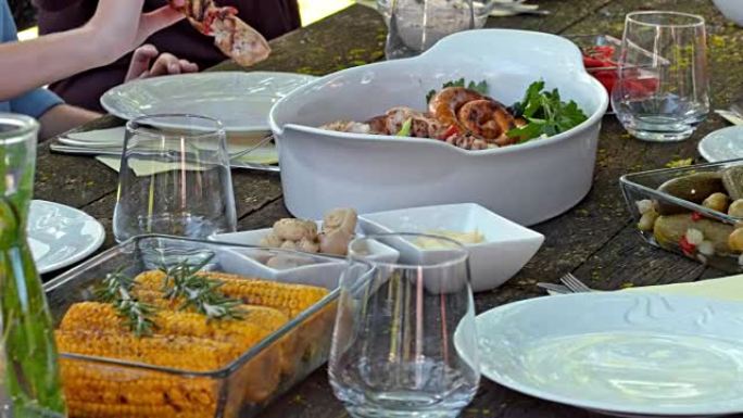 人们从野餐桌上的盘子里拿食物
