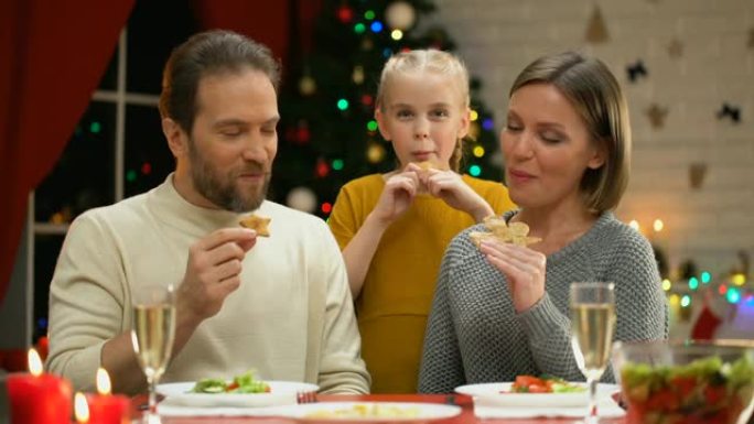 快乐的家庭吃传统的圣诞饼干，看相机，传统