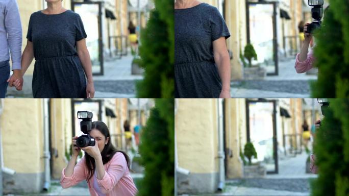 女人用相机拍摄著名演员夫妇街的照片，刺探狗仔队