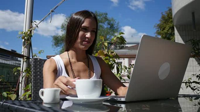 优雅的女商人坐在户外咖啡馆享受咖啡