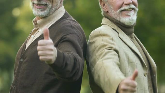 两名男性养老金领取者表现出竖起大拇指，快乐和安全的老年，社会保障