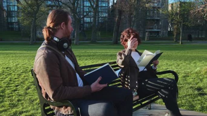 一男一女在公园看书的手持镜头