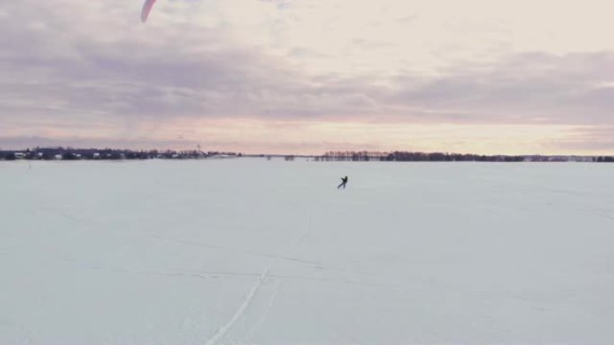 在冬季用滑雪板或滑雪板进行风筝冲浪。在风中在冰上溜冰。美丽的彩色的帆