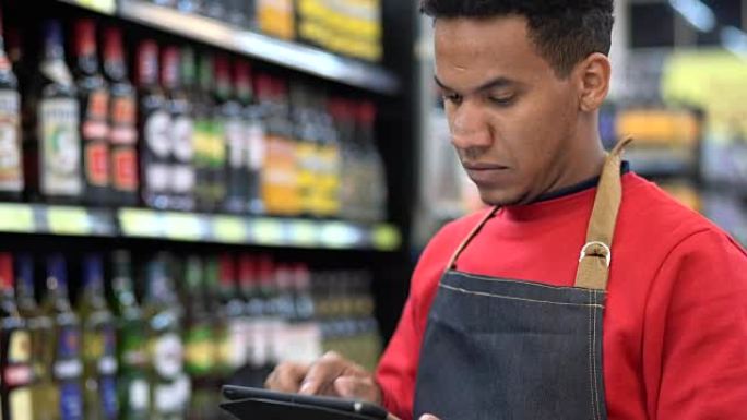 商人在超市的数字平板电脑中检查库存