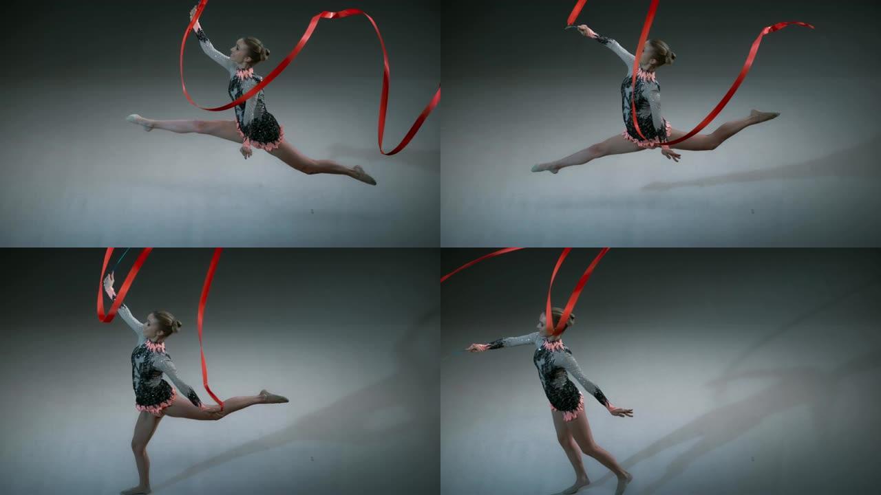 SLO MO SPEED RAMP LD上方的艺术体操运动员在旋转红丝带的同时进行了一次跳跃