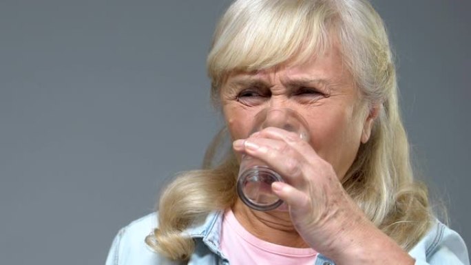 老年妇女服用苦味药，喝水，酸味