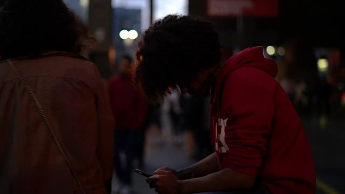 年轻的非洲裔男子在城市使用手机
