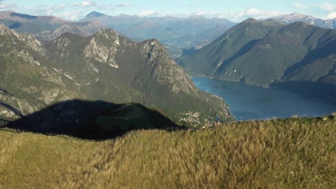 徒步旅行者在山脊上的空中无人机视图，下面的湖
